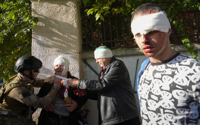 People receive medical treatment at the scene of Russian strikes in Kyiv, Ukraine, Oct. 10, 2022 (AP Photo/Efrem Lukatsky)