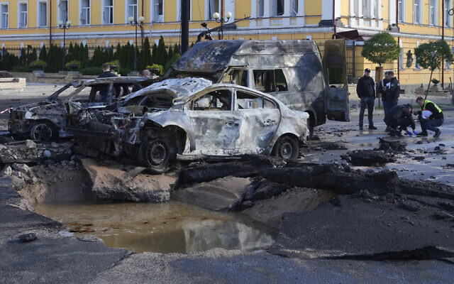 Damaged cars are seen at the scene of Russian shelling, in Kyiv, Ukraine, October 10, 2022. (AP Photo/Efrem Lukatsky)