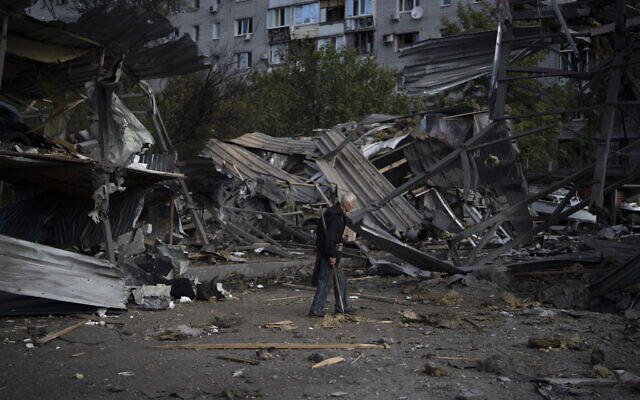 An elderly man walks past a car shop that was destroyed after a Russian attack in Zaporizhzhia, Ukraine, October 11, 2022. (Leo Correa/AP)