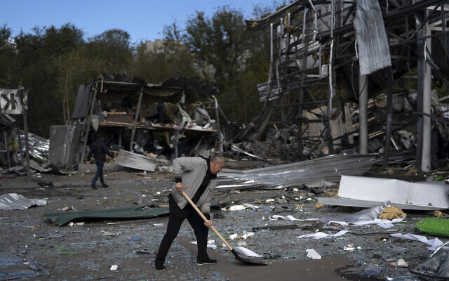Illustrative: An employee cleans the debris at the remains of a car shop that was destroyed after a Russian attack in Zaporizhzhia, Ukraine, October 11, 2022. (Leo Correa/AP)