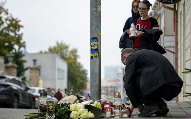 People lay flowers and light candles at the scene of Wednesday's attack on Zamocka Street in Bratislava, Slovakia, October 13, 2022. (Pavol Zachar/TASR via AP)