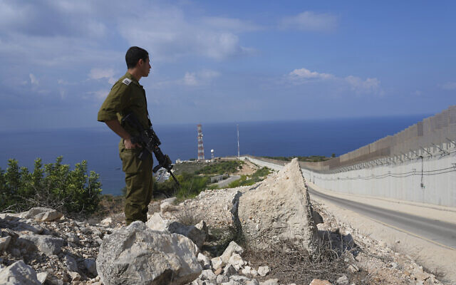 An Israeli soldier stands near the fence on the Israeli border with Lebanon in Rosh Hanikra , October 14, 2022. (AP Photo/ Tsafrir Abayov)