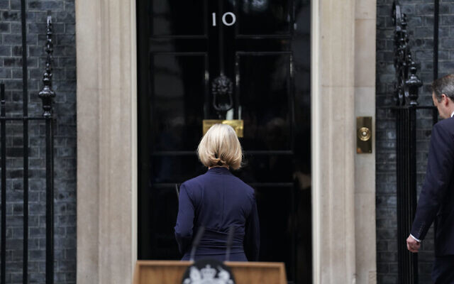 Liz Truss, followed by her husband Hugh O'Leary, right, walks back into 10 Downing Street after making a statement where she announced her resignation as Prime Minister, in London, October 20, 2022.  (Stefan Rousseau/PA via AP)