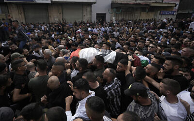 Mourners carry the body of Tamer al-Kilani, a member of the Palestinian terror organization Lion’s Den, who the group said was killed by an explosive device planted in a motorcycle, during his funeral in the West Bank city of Nablus, October 23, 2022. (AP Photo/Majdi Mohammed)