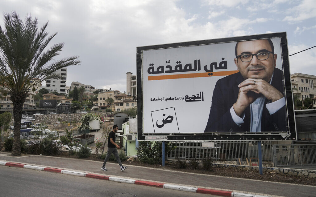 A man walks by an election campaign billboard showing Sami Abu Shehadeh, head of the nationalist Balad party, in the northern Israeli city of Umm al-Fahm, Friday, Oct. 21, 2022. (AP/Mahmoud Illean)