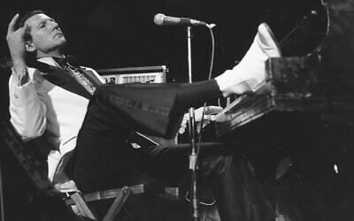 Jerry Lee Lewis props his foot on the piano as he lays back and acknowledges the applause of fans during the fifth annual Rock 'n' Roll Revival at New York's Madison Square Garden on March 14, 1975. (AP Photo/Rene Perez, File)