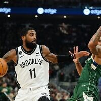 Brooklyn Nets' Kyrie Irving tries to get past Milwaukee Bucks' George Hill during the first half of an NBA basketball game, October 26, 2022, in Milwaukee. (AP Photo/Morry Gash)