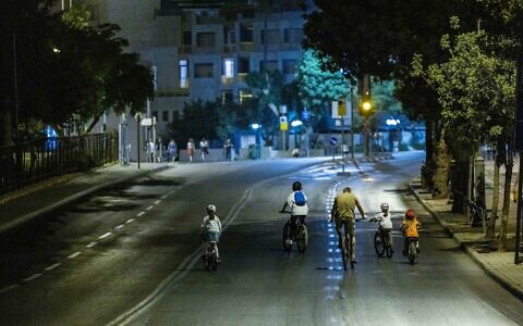 People ride bicycles and walk along empty roads in Jerusalem, on the evening of Yom Kippur, the Day of Atonement, October 4, 2022. (Yonatan Sindel/Flash90)