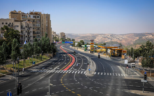 People walk on the empty road at the entrance to Jerusalem, on Yom Kippur, the Day of Atonement, October 5, 2022 (Jamal Awad/Flash90)