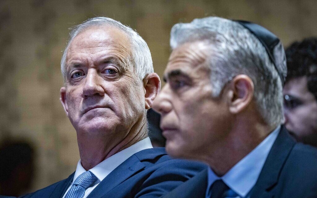 Prime Minister Yair Lapid, right, and Defense Ministrer Benny Gantz at a state memorial ceremony for the fallen soldiers of the Yom Kippur War, at the military cemetery memorial hall on Mount Herzl, October 6, 2022. (Olivier Fitoussi/Flash90)