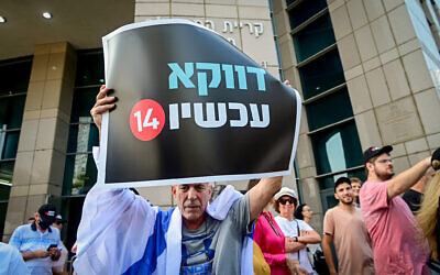 Channel 14 workers and supporters protest against Yair Lapid, the then-prime minister, in Tel Aviv on October 11, 2022. The poster reads: "Especially now: 14" (Avshalom Sassoni/Flash90)