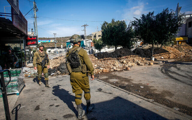 Israeli soldiers block the entrance to Deir Sharaf, near Nablus in the West Bank on October 12, 2022, (Nasser Ishtayeh/Flash90)