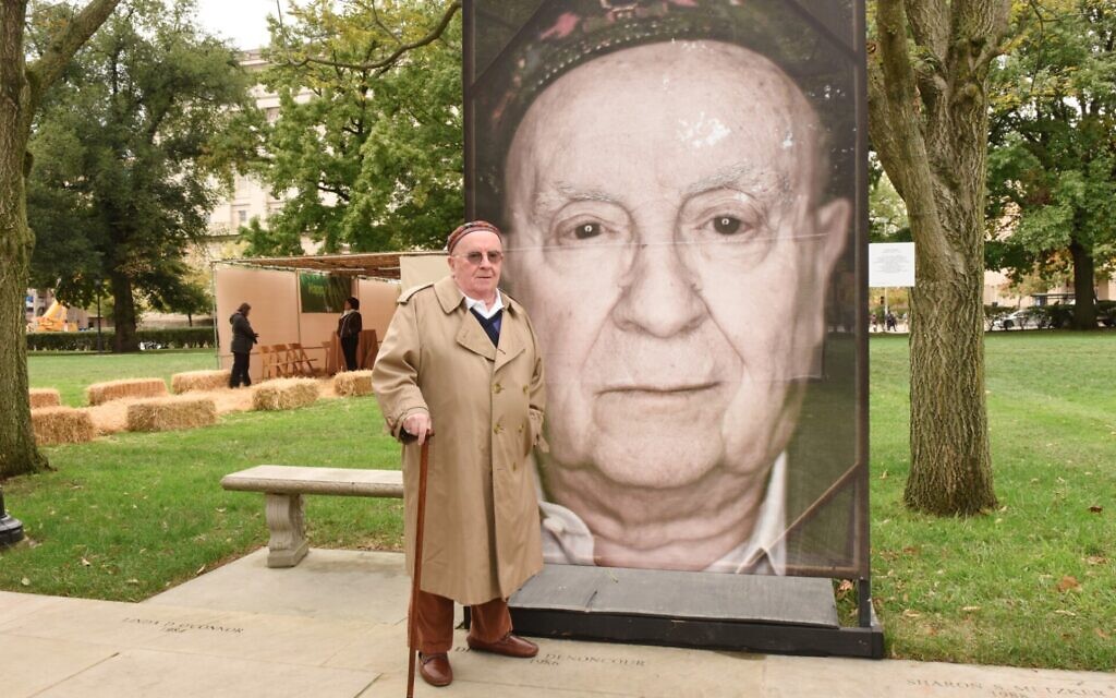 Judah Samet stands next to his portrait, part of Luigi Toscano’s “Lest We Forget” project at the University of Pittsburgh in 2019. (Photo by Hector Corante, courtesy of Holocaust Center of Pittsburgh via JTA)
