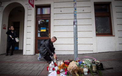 A man places a candle on the pavement at Zamocka Street in Bratislava after a "radicalized teenager" murdered two men there, October 13, 2022. (Vladimir Simicek/AFP/Getty Images via JTA)
