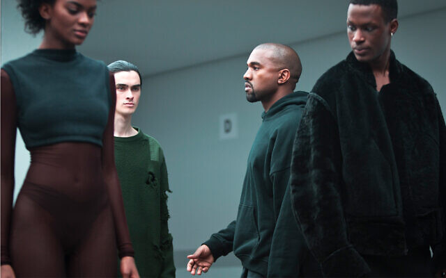 Kanye West, second from right, makes final rounds before the showing of the Kanye West Adidas Fall 2015 collection at Fashion Week in New York, Feb. 12, 2015. (AP Photo/Bebeto Matthews)