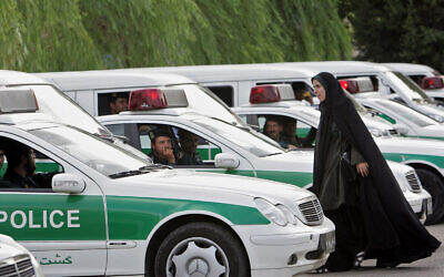 An Iranian morality policewoman walks between morality police vehicles, preparing to start a crackdown to enforce Islamic dress code in Tehran, July 23, 2007. (Behrouz Mehri/AFP)