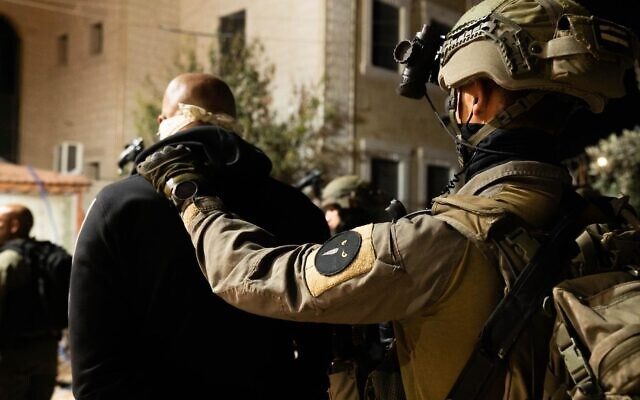 Israeli soldiers arrest a wanted Palestinian man in the West Bank on October 16, 2022. (Israel Defense Forces, file)