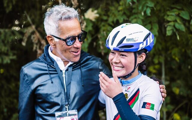 Afghanistan's national cycling champion Fariba Hashimi (R) meets the owner of Women’s WorldTour team Israel – Premier Tech Roland, Sylvan Adams, in Aigle, Switzerland, October 23, 2022. (Noa Arnon/courtesy)