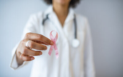 Illustrative image: a doctor holds up a pink ribbon for breast cancer awareness. (dragana991 via iStock by Getty Images)