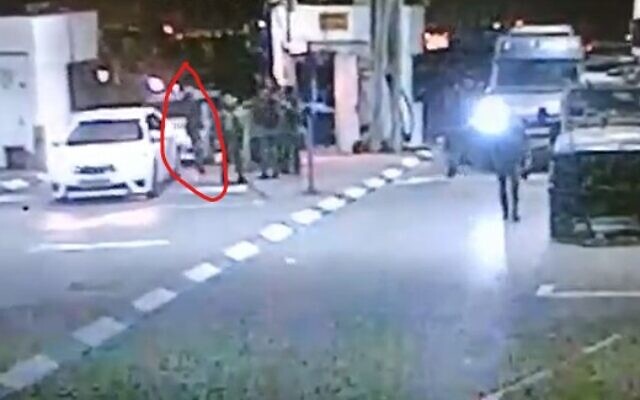 A Palestinian gunman (circled in red) approaches a group of IDF soldiers and civilian guards, apparently undetected, at an East Jerusalem checkpoint on October 8 2022 (Screencapture)
