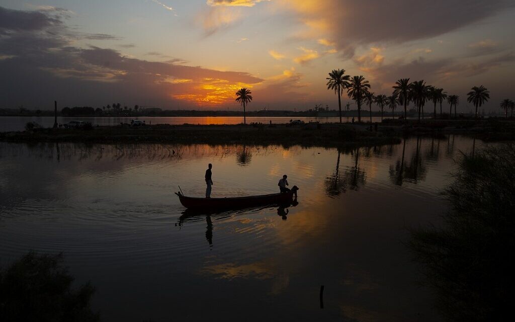 Fishermen sail in a boat in the Shatt al-Arab waterway, formed at the confluence of the Euphrates and Tigris rivers, as the sun sets over Iraq's southern city of Basra on October 30, 2022. (Hussein FALEH / AFP)