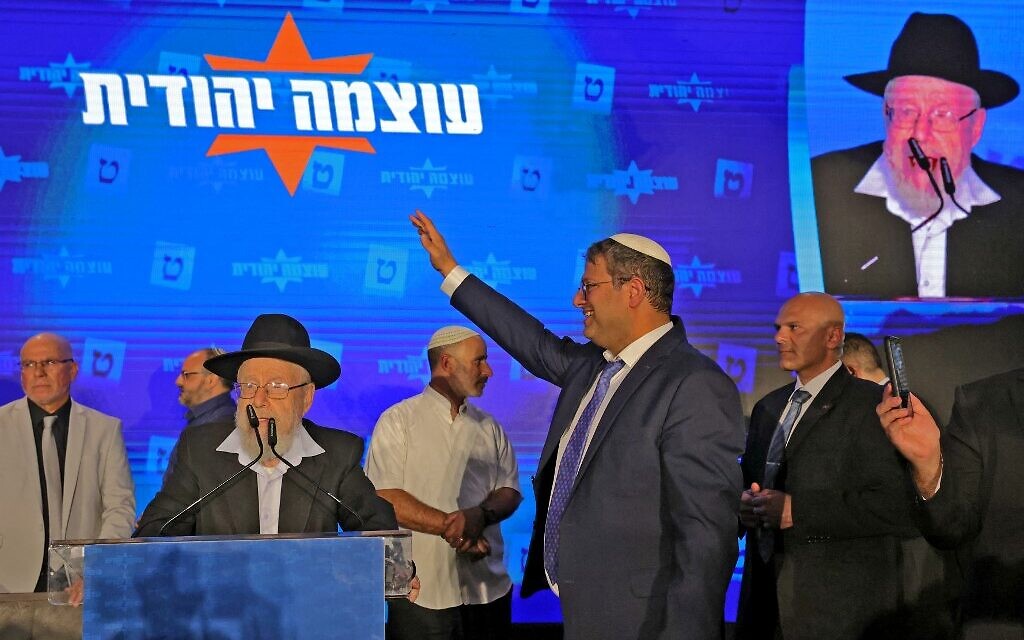 Otzma Yehudit far-right party Itamar Ben Gvir gestures to supporters at campaign headquarters in Jerusalem early on November 2, 2022, after the end of voting for national elections. At left is Rabbi Dov Lior. (Jalaa MAREY / AFP)