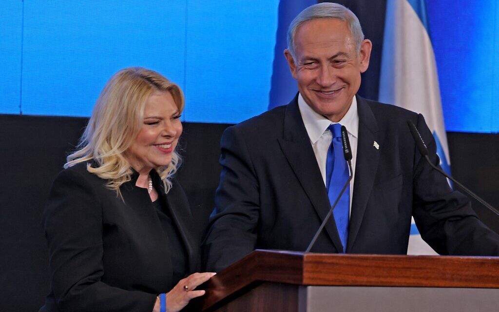 Leader of the Likud party Benjamin Netanyahu addresses supporters, flanked by his wife Sara, at campaign headquarters in Jerusalem early on November 2, 2022, after the end of voting for national elections (Menahem Kahana / AFP)