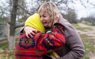 50-year school head Svitlana Striletska (R) reacts with 84-year Galina Timofievna (L), as they hug each other in the liberated village of Pravdyne, Kherson region, Ukeraine, on November 12, 2022. (STRINGER / AFP)