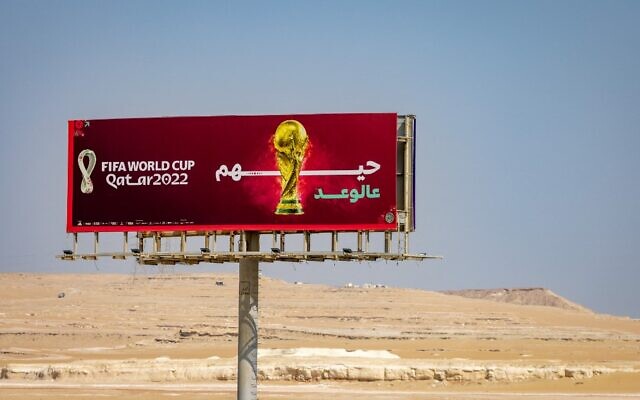 A road sign for the Qatar 2022 World Cup soccer tournament is seen next to a highway near Abu Samra, western Qatar on November 15, 2022. (Odd Andersen/AFP)