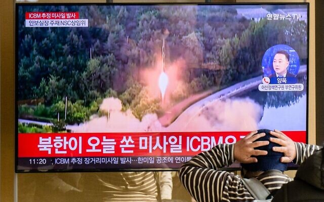 A man watches a television showing a news broadcast with file footage of a North Korean missile test, at a railway station in Seoul on November 18, 2022. (Anthony WALLACE / AFP)