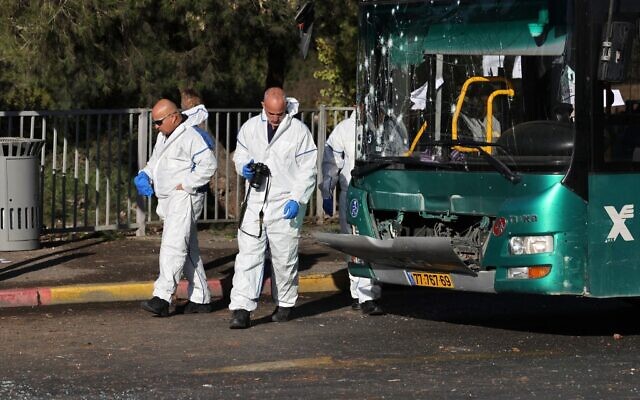 Israeli forensic experts collect evidence at the scene of an explosion at a bus stop in Jerusalem on November 23, 2022 (AHMAD GHARABLI / AFP)
