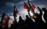 Protestors wave Iranian pre-Islamic revolution flags in front of the United Nations headquarters as they attend a rally amid a special session of the UN Human Rights Council on the situation in Iran, in Geneva on November 24, 2022. (VALENTIN FLAURAUD / AFP)