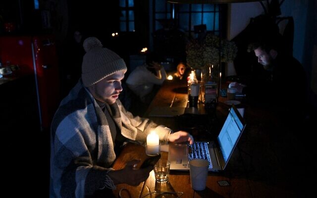 People sit in a coffee shop in Lviv as the city experiences a scheduled power outage on November 24, 2022. (Yuriy Dyachyshyn / AFP)