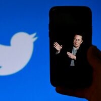 A phone screen displays a photo of Elon Musk with the Twitter logo shown in the background, in Washington, DC, October 4, 2022. - (OLIVIER DOULIERY / AFP)
