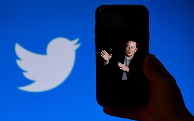 A phone screen displays a photo of Elon Musk with the Twitter logo shown in the background, in Washington, DC, October 4, 2022. (Olivier Douliery/AFP)