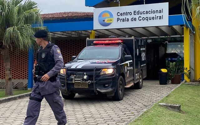 Police officers stand at the entrance of the Praia de Coqueiral Educational Centre, one of two schools where a shooting took place, after an armed man opened fire, in Aracruz, Espirito Santo State, Brazil, on November 25, 2022. (KADIJA FERNANDES / AFP)