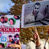 People hold placards bearing portraits of Iranian rapper Toomaj Salehi (R), who is arrested in Iran, and portraits of children (L), who were killed during the protests in Iran, during a rally in support of Iranian women in Istanbul, on November 26, 2022. (Yasin AKGUL / AFP)