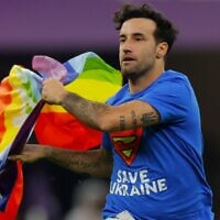 A man wearing a t-shirt reading "Save Ukraine" runs on the pitch waving a rainbow LGBT flag on the pitch during the Qatar 2022 World Cup Group H football match between Portugal and Uruguay at the Lusail Stadium in Lusail, north of Doha on November 28, 2022. (Odd ANDERSEN / AFP)