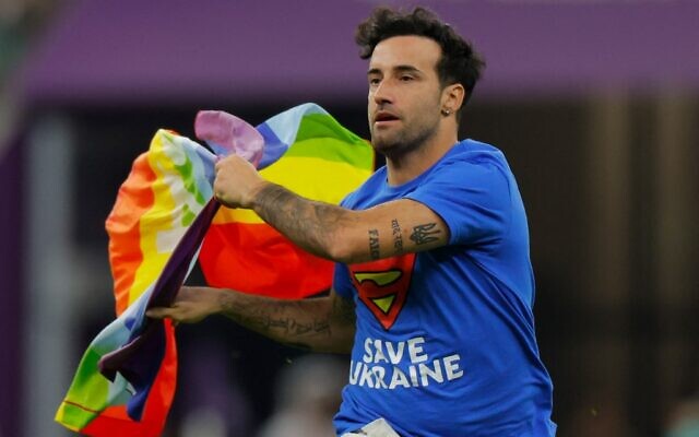 A man wearing a t-shirt reading "Save Ukraine" runs on the pitch waving a rainbow LGBT flag on the pitch during the Qatar 2022 World Cup Group H football match between Portugal and Uruguay at the Lusail Stadium in Lusail, north of Doha on November 28, 2022. (Odd ANDERSEN / AFP)