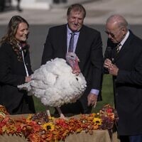 US President Joe Biden, right, pardons Chocolate, the National Thanksgiving Turkey, as he is joined by the 2022 National Turkey Federation Chairman Ronnie Parker and Alexa Starnes, daughter of the owner of Circle S Ranch, on the South Lawn of the White House in Washington, DC, November 21, 2022. (Nathan Howard/Getty Images/AFP )