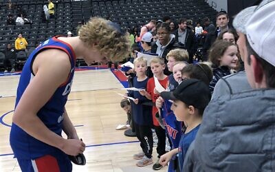 NBA G League player Ryan Turell signs a fan's yarmulke following his game with Detroit's Motor City Cruise, November 17, 2022. The Yeshiva University graduate is the first Orthodox Jew to play for an NBA franchise team at any level. (Andrew Lapin/JTA)
