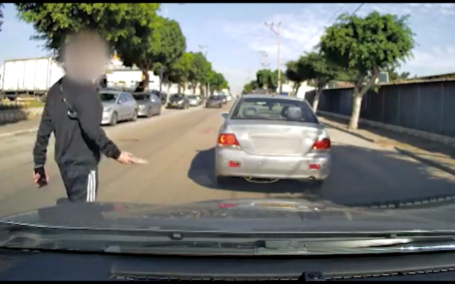 A man walks away after allegedly threatening a driver with a knife in the middle of the road, in the central city of Rishon Lezion, November 28, 2022. (Twitter video screenshot: used in accordance with Clause 27a of the Copyright Law)