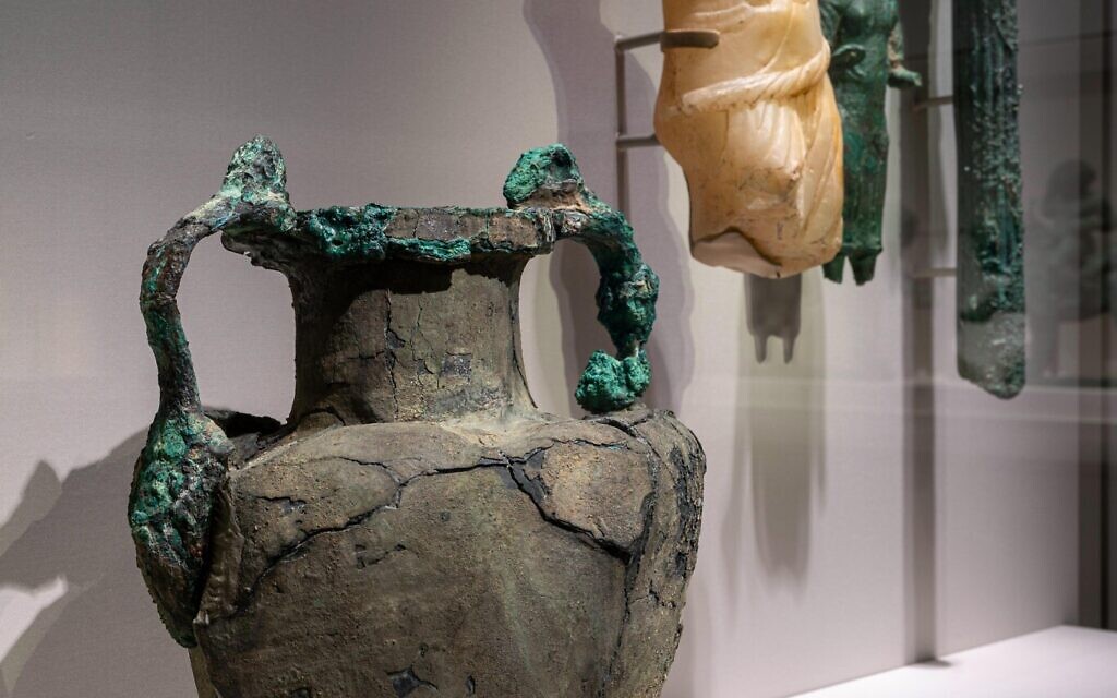 In the foreground, an amphora with handles originating from silenus masks at the shoulder and terminating in lion's heads at the rim, 2nd century BCE - 1st century CE, Greece or Rome, bronze. (Courtesy of Smithsonian/ Colleen Dugan)