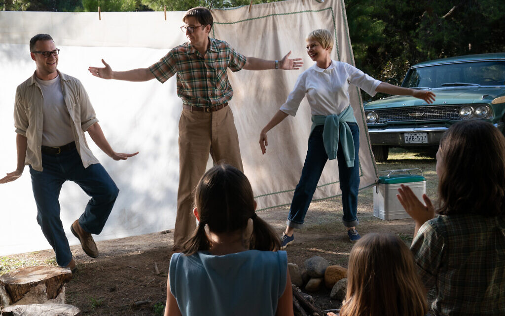 Background to foreground, left to right: Bennie Loewy (Seth Rogen), Burt Fabelman (Paul Dano), Mitzi Fabelman (Michelle Williams), Natalie Fabelman (Keeley Karsten, back to camera), Lisa Fabelman (Sophia Kopera, back to camera) and Reggie Fabelman (Julia Butters, back to camera) in 'The Fabelmans,' co-written, produced and directed by Steven Spielberg. (Courtesy Universal Pictures)