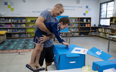 A man and his son vote during Israeli elections in Tel Aviv, Israel, Tuesday, Nov 1, 2022. (AP/Oded Balilty)