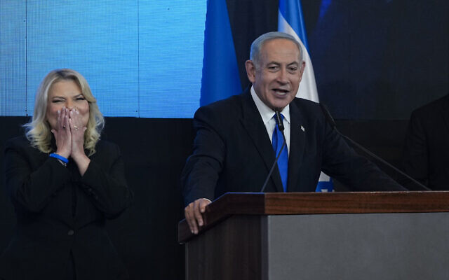 Likud leader Benjamin Netanyahu addresses supporters at the party's campaign headquarters in Jerusalem early on November 2, 2022, with his wife Sara at his side. (AP Photo/Tsafrir Abayov)