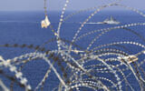 A UNIFIL Navy vessel seen through barbed wires patrols in the Mediterranean Sea, next to a UN post along the border known as Ras Naqoura, where Lebanese and Israeli delegations met to finalize a maritime border agreement, off the southern town of Naqoura, Lebanon, October 27, 2022. (Mohammed Zaatari/AP)