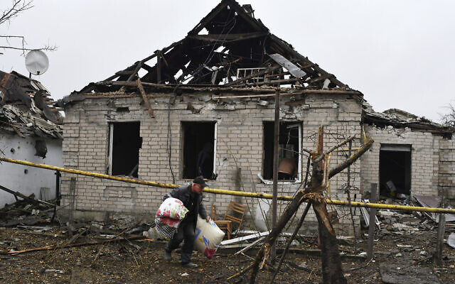 A man carries pillows from his destroyed apartment building after Russian shelling in Pokrovsk, Donetsk region, Ukraine, Nov. 4, 2022. (AP Photo/Andriy Andriyenko)