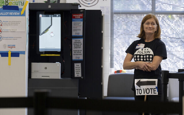 A poll worker waits to direct voters during the midterm election at Ridgeview Charter Middle School in Sandy Springs, Georgia, November 8, 2022. (Ben Gray/AP)