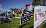 Lee County voters stand beside campaign signs as they wait in line to cast their ballots at Northeast Regional Library in Cape Coral, Fla, on Election Day, Tuesday, Nov. 8, 2022. (AP/Rebecca Blackwell)